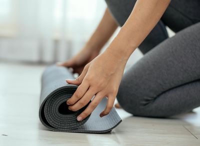 A yoga mat rolled out in a quiet, sunlit room.